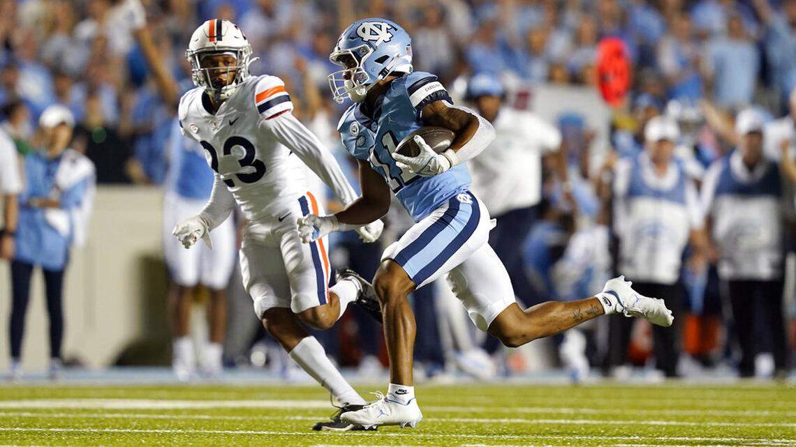 Virginia cornerback Josh Hayes (11) chases North Carolina wide receiver Josh Downs (11) during the first half of an NCAA college football game in Chapel Hill, N.C., Saturday, Sept. 18, 2021. (AP Photo/Gerry Broome)