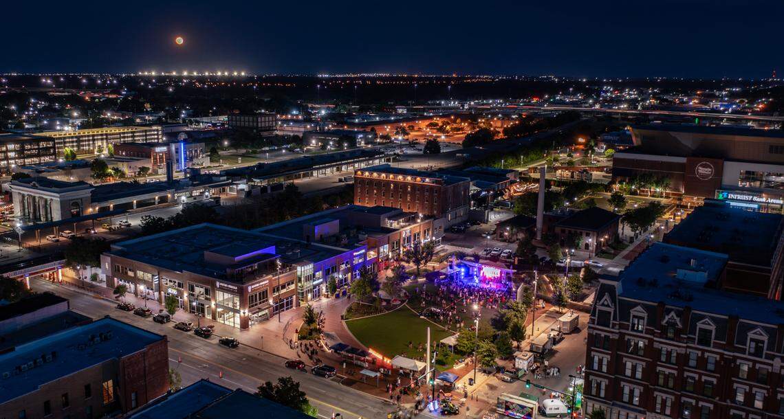 A full moon rises in the southeast while Elsewhere Fest attendees enjoy a show by Blue DeTiger at Naftzger Park on Friday night.