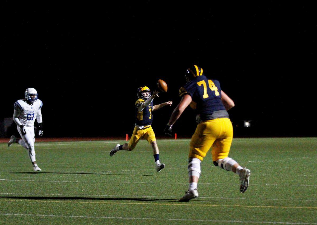 Reagan Jones, a Wichita Northwest high school quarterback, throws a shovel pass to running back Breece Hall in the Grizzlies 55-26 win over Kapaun on Friday. (Sept. 28, 2018)