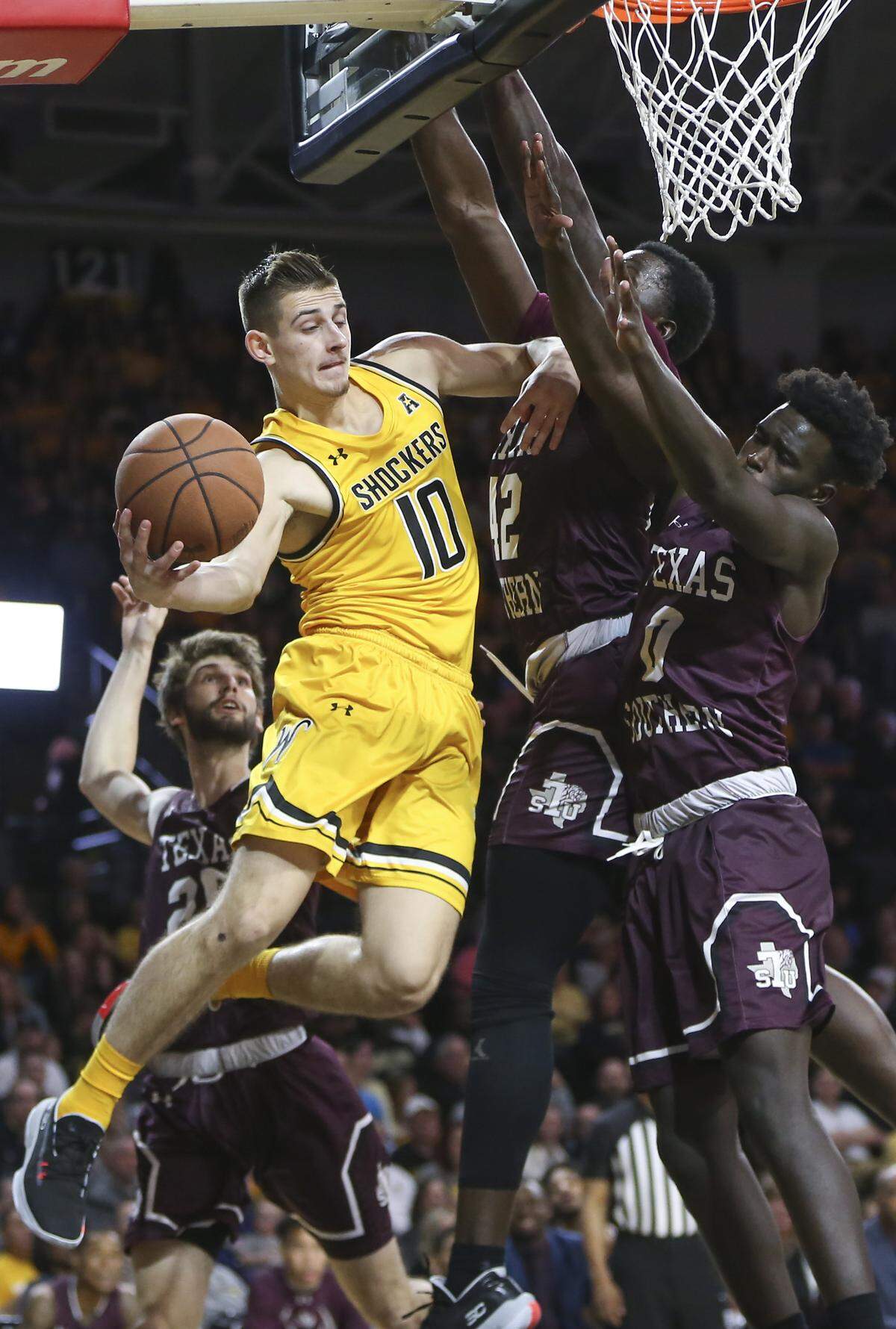 Wichita State’s goes around a trio of Texas Southern defenders during the first half of their 69-63 win at Koch Arena on Saturday.