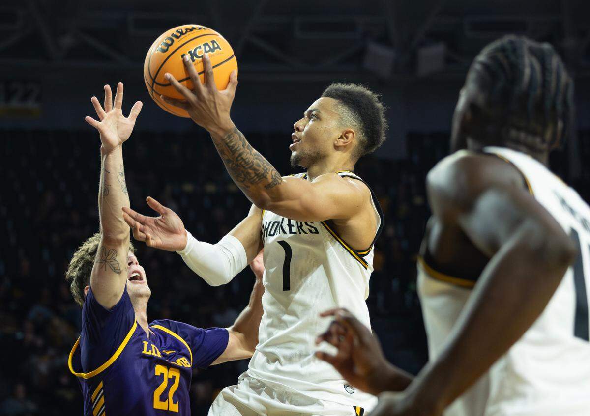 Wichita State’s Xavier Bell goes up for a shot against Lipscomb’s Joe Anderson during the first half of their season opener on Monday night at Koch Arena.