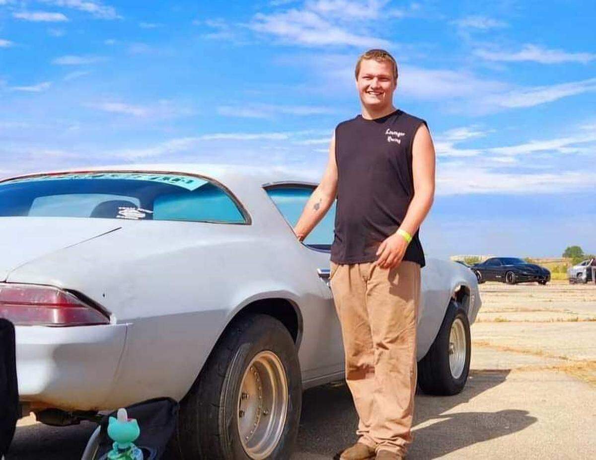 Damion Lininger poses next to his 1980 Chevrolet Camaro that he drag races.