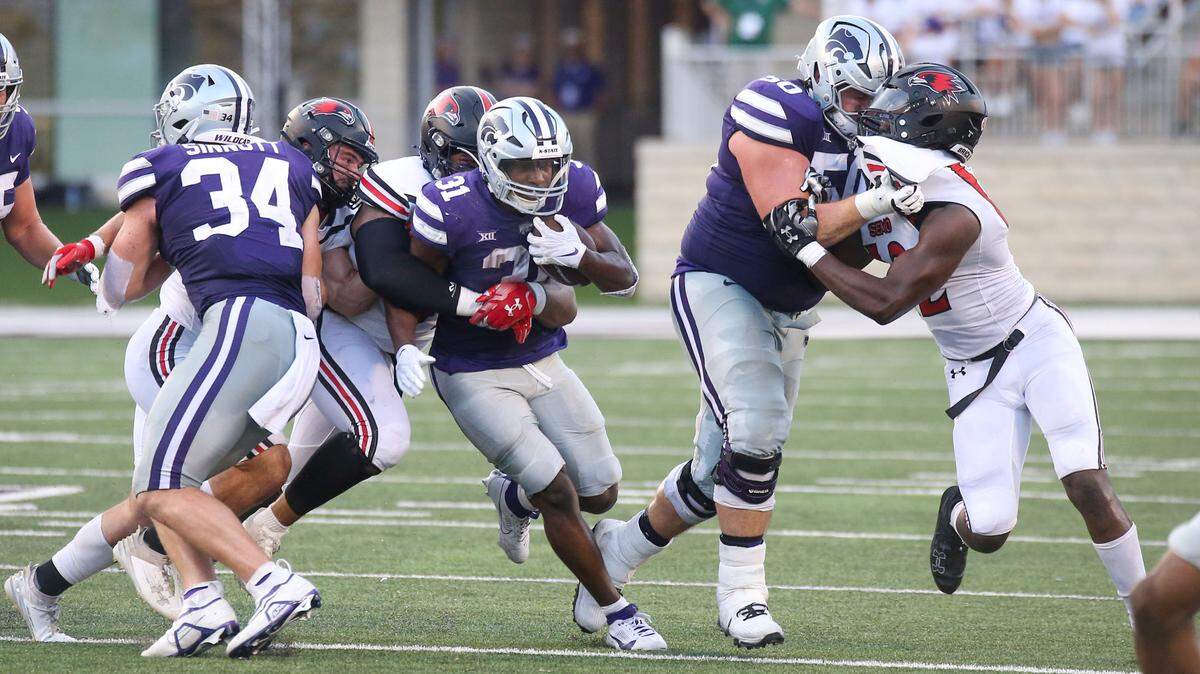 Kansas State Wildcats running back DJ Giddens (31) is tacked by Southeast Missouri State Redhawks defensive lineman LaWilliam Holmes (91) and linebacker Jacob Morrissey (44) during the second quarter at Bill Snyder Family Football Stadium on Sept. 2, 2023.