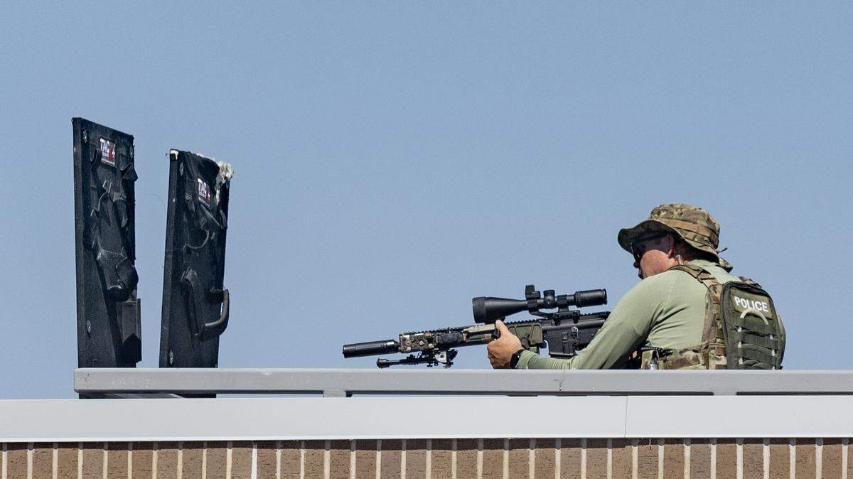 A Wichita Police sniper sets up on the roof the of the Martin Pringle Law office in downtown Wichita on Wednesday during a standoff across the street.