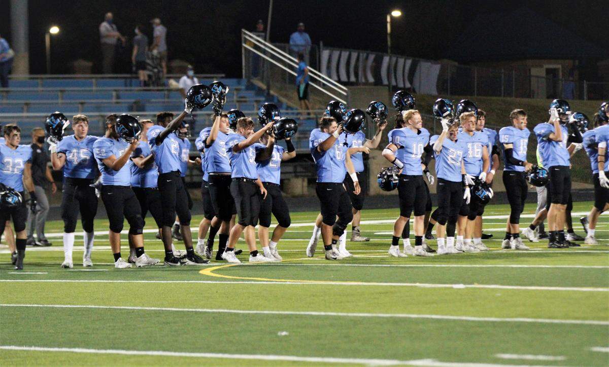 Eisenhower football players lift their helmets after its game against Hays High.