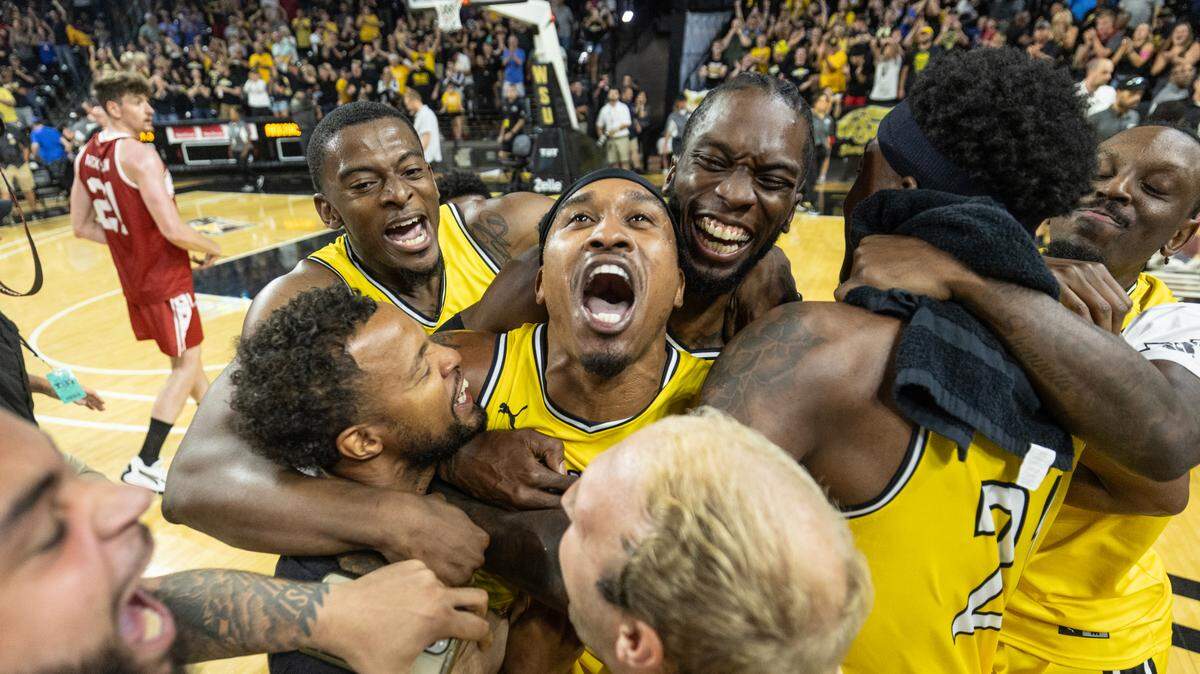 Tyrus McGee is mobbed by his Aftershocks teammates after his three pointer won the game against Team Arkansas on Sunday at The Basketball Tournament at Koch Arena.