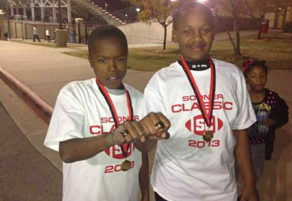 Knowledge McPherson and his cousin, Wesley Adkins, show off their championship rings after winning the Sooner Classic football tournament in Tulsa while they played for the Wichita Cowboys.