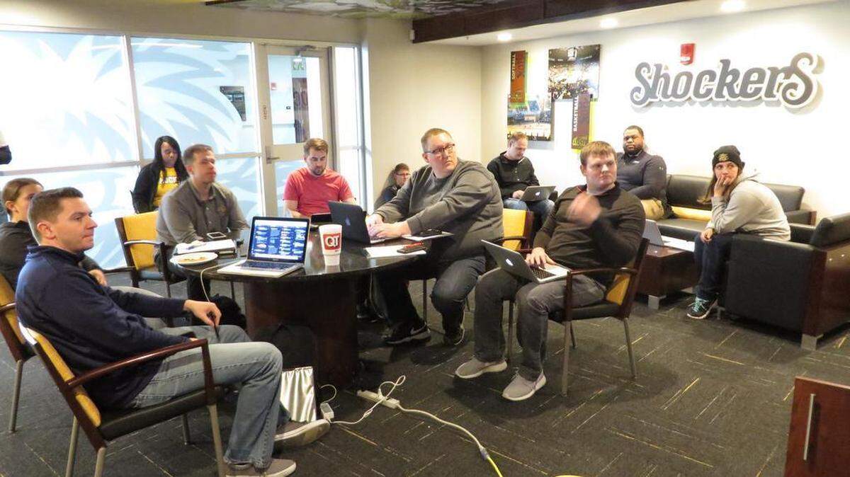 Wichita State athletic department and tournament staff watch the team selections come in at the tournament war room at Koch Arena.