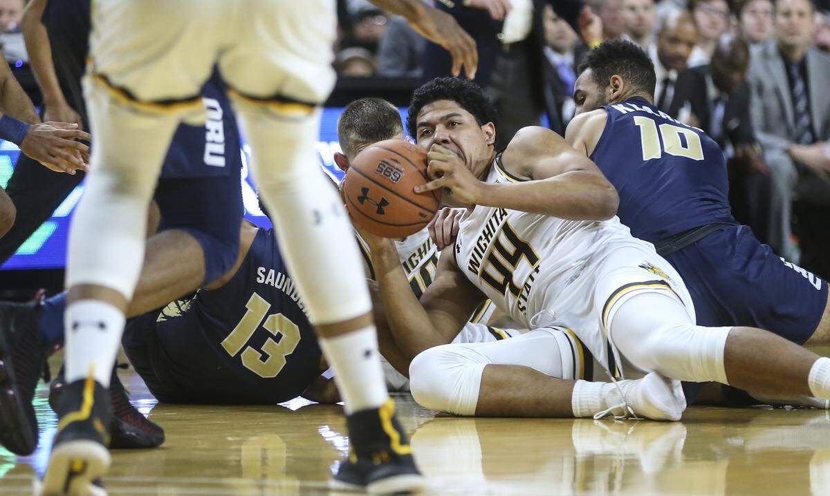 Wichita State forward Isaiah Poor Bear-Chandler kicks out a loose ball to teammate Jaime Echenique during the first half of their game against Oral Roberts at Koch Arena on Wednesday.