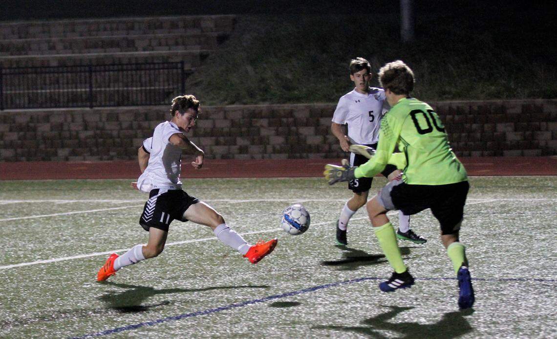 Maize South senior forward Bryce Bowman fires on goal against Trinity Academy senior goalkeeper Chason Linder during the Mavericks’ 5-1 road win Friday. (Aug. 24, 2018)