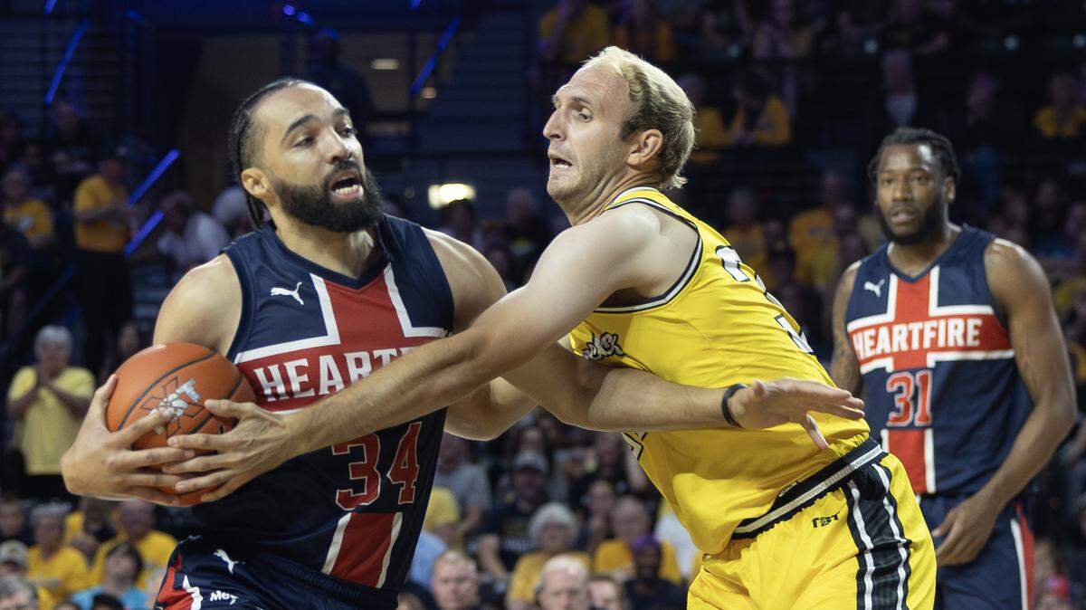 AfterShocks’ Conner Frankamp fouls Team Heartfire’s Davin White during the first half on Tuesday night at Koch Arena. Team Heartfire defeated the AfterShocks 76-53 to advance to the tournament semifinal in Philadelphia.