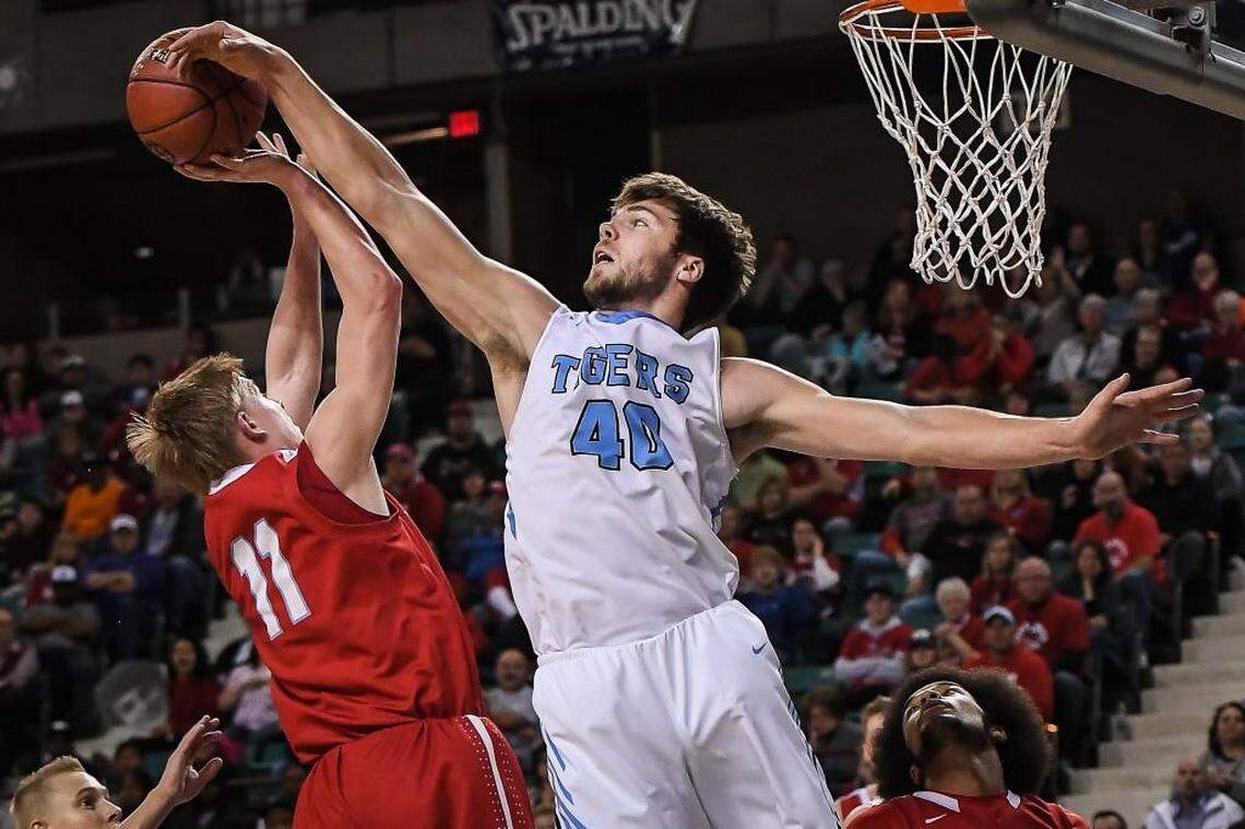 Eisenhower’s Matt Pile, right, blocks a shot by Shawnee Heights’ Tyler Zenter.