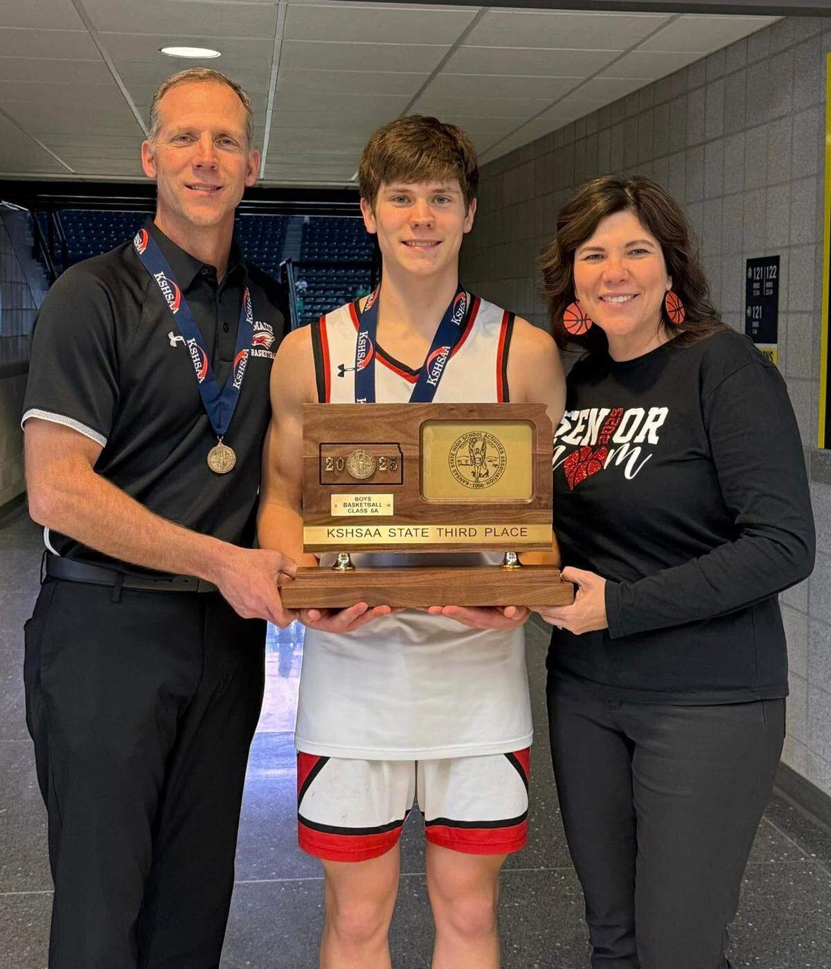 Chris and Lena Grill pose for a picture with their youngest son, Alec, after Maize won the third-place trophy at the Class 6A state tournament this past weekend.