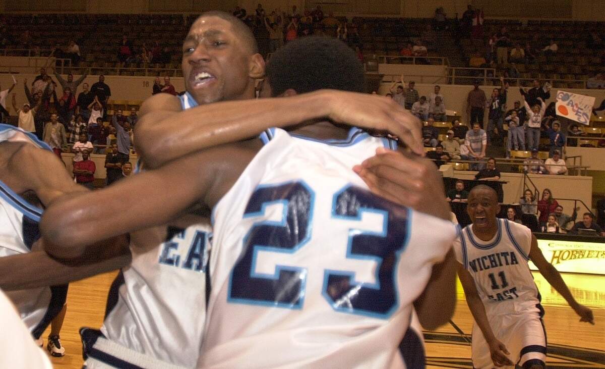 Wichita East’s Taj Gray hugs teammate Brent Freeman after Freeman made the winning basket in a state basketball game.