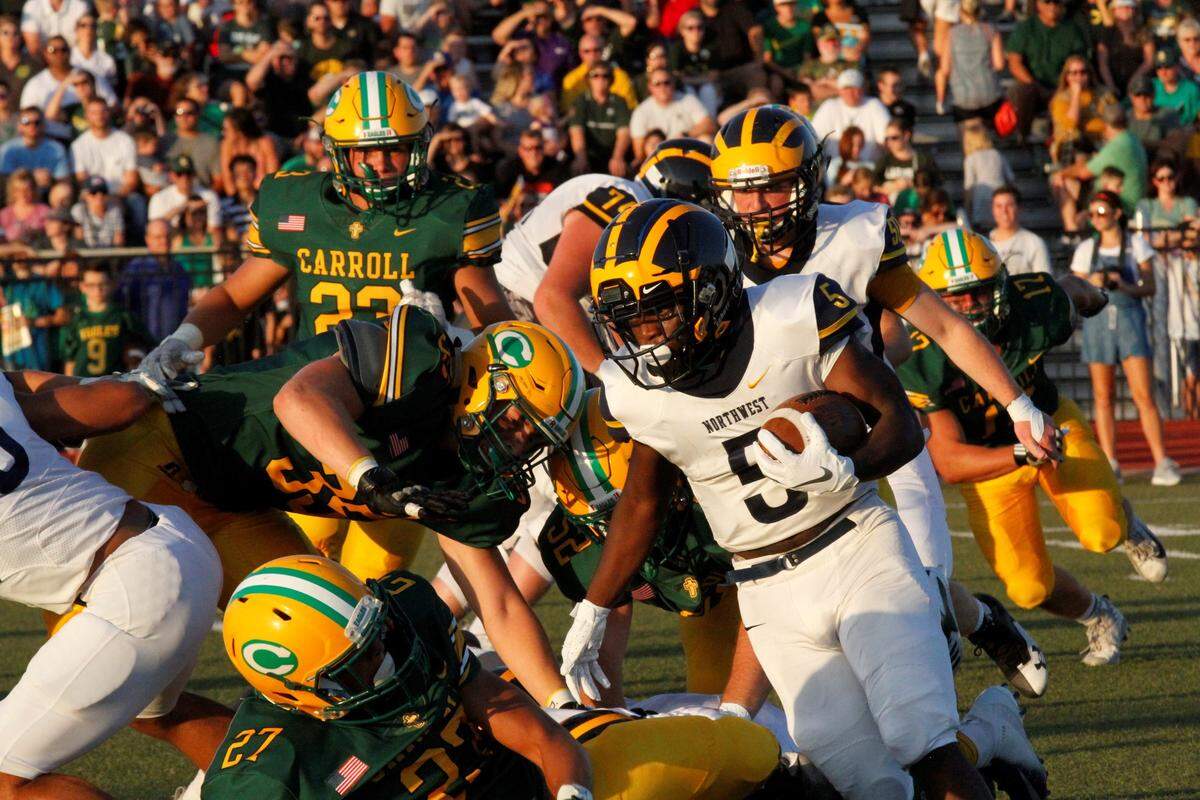 Northwest senior running back Roy Johnson cuts upfield as Bishop Carroll defenders fight to get to him during the Grizzlies’ 23-22 road victory Friday night. (Aug. 31, 2018)