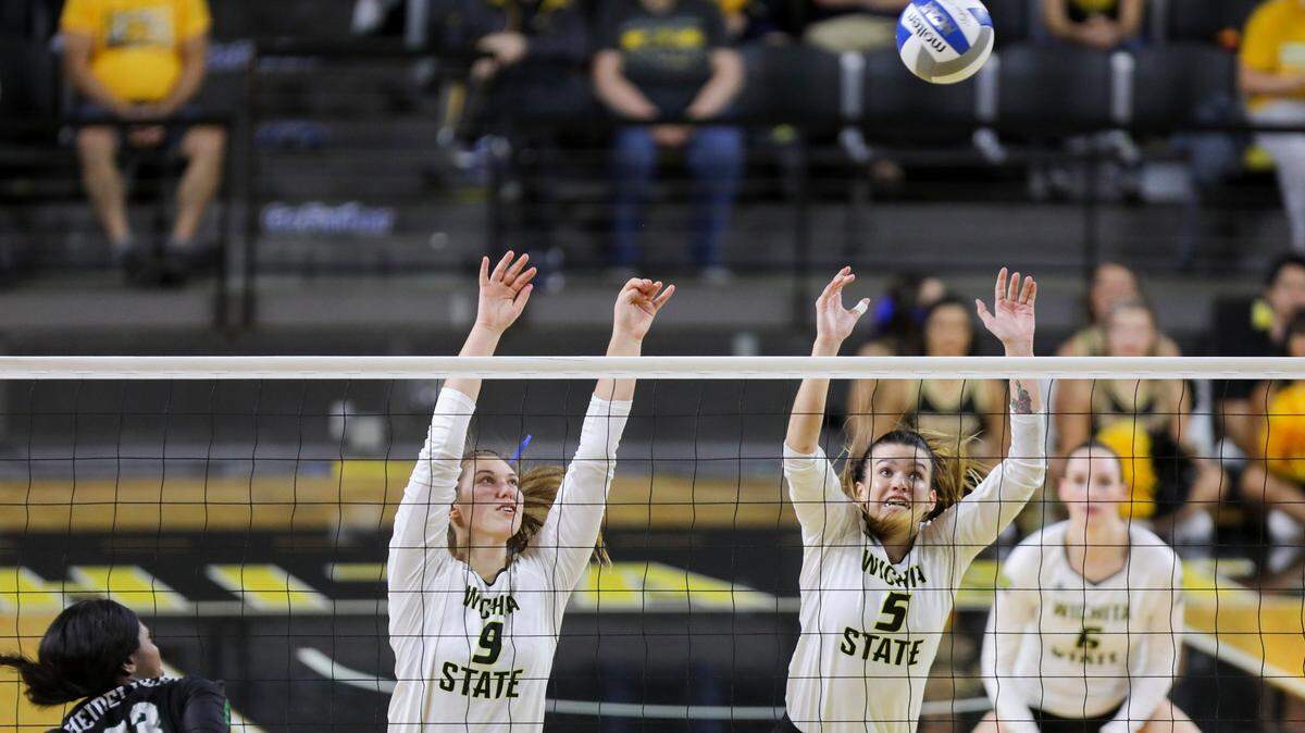 Wichita State outside hitter Alex Koon and middle blocker Abby Pugh attempt to block a shot against the Tulane Green Wave during the home-opener in Koch Arena. (Sept. 21, 2018)