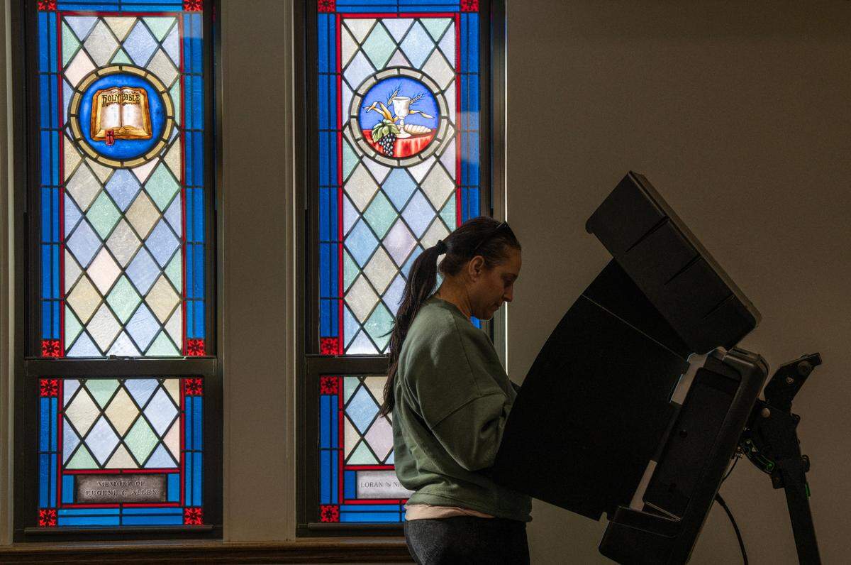 A voter looks over a ballot at Grace Presbyterian Church. Voters in the Wichita school district are considering whether to approve a $450 million bond issue to modernize schools.