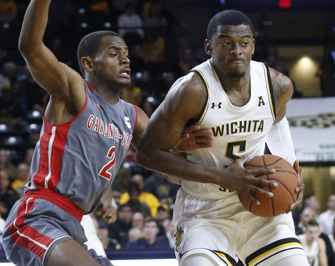 Gardner-WebbÕs Eric Jamison (2) reaches inside of Wichita StateÕs Trey Wade trying to steal the ball Tuesday night at Koch Arena. (November 19, 2019)
