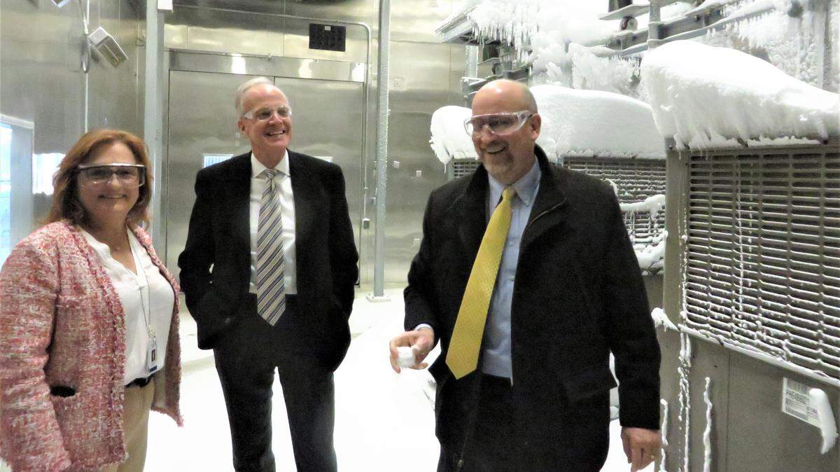 As Johnson Controls executive Liz Haggerty and Sen. Jerry Moran look on, Wichita Mayor Jeff Longwell, right, plays with a snowball he made in a cold room at the company’s factory in north Wichita. The room is used to test heating and air conditioning components in simulated severe weather conditions.