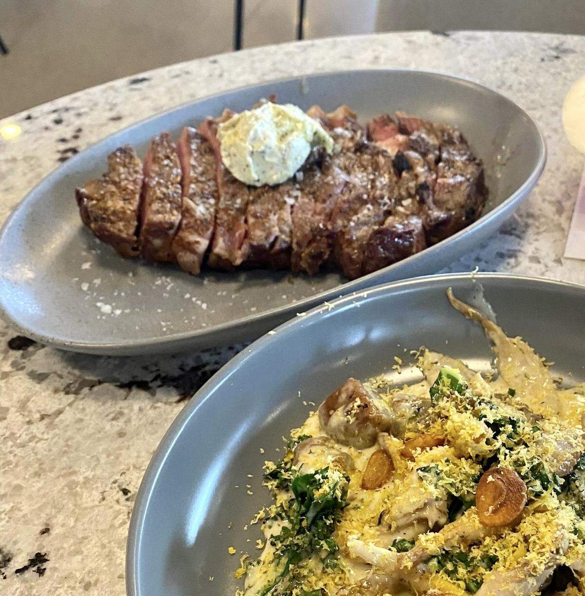 Among the items on the First Mile Kitchen menu: top a rib eye with bone marrow sage butter, and (bottom right) winter squash gnocchi with roasted kale, fried garlic, oyster mushrooms and cured smoked duck yolk.
