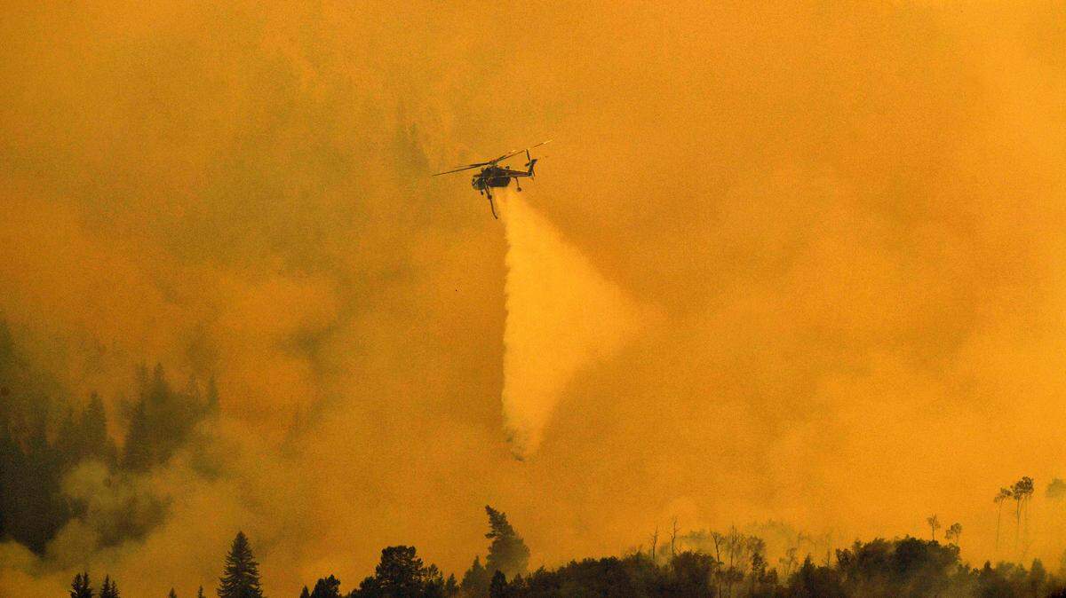 A Sikorsky Skycrane helicopter drops water on the Grizzly Creek Fire on the east end of Glenwood Canyon, Monday, Aug. 17, 2020 near Glenwood Springs, Colo. Four large wildfires continue to burn in hot and dry weather in Colorado. (Helen H. Richardson/The Denver Post via AP)
