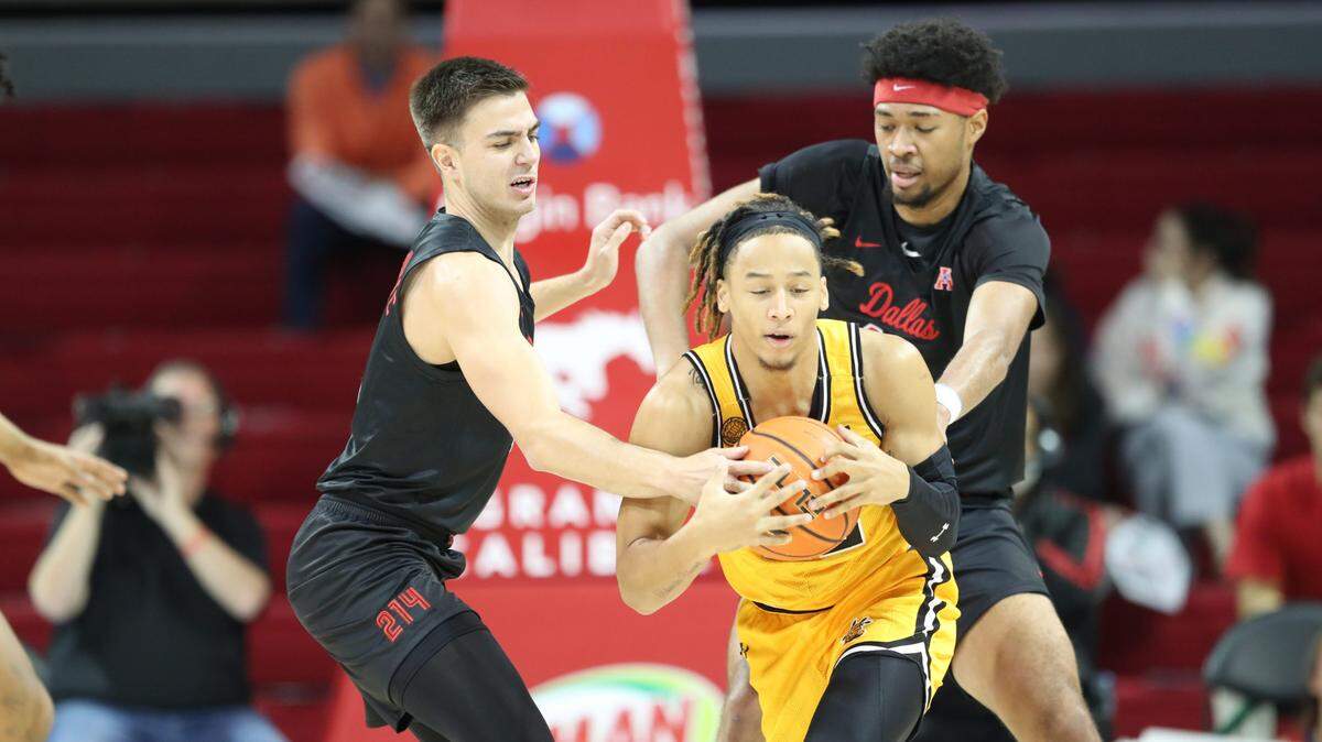 Wichita State’s Shammah Scott tries to break free from two SMU defenders in Sunday’s 71-69 win for the Shockers. Scott played a key role off the bench in the win.