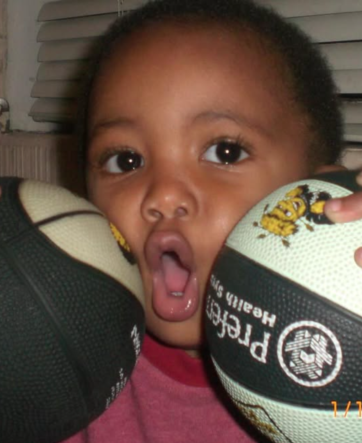 Pierre Couisnard as a young child with Wichita State basketballs. His father, P.J., is a former star player for the Shockers.
