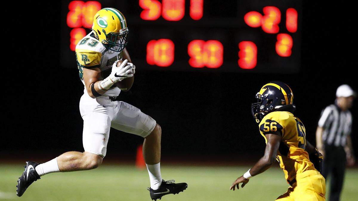 Bishop Carroll’s Clay Cundiff, left, catches a pass as Northwest’s Percelle Finch defends in the third quarter Thursday night. Bishop Carroll won 40-35.