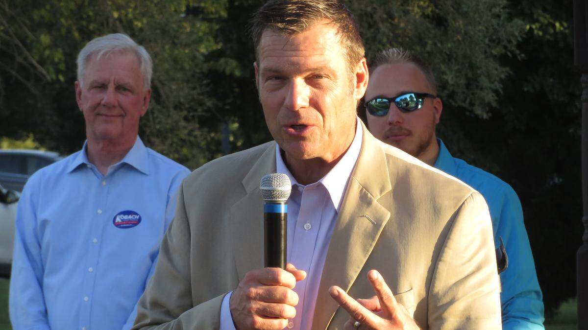 With running mate Wink Hartman looking on, governor candidate Kris Kobach emphasizes a point to supporters attending a campaign rally in Haysville Thursday evening.
