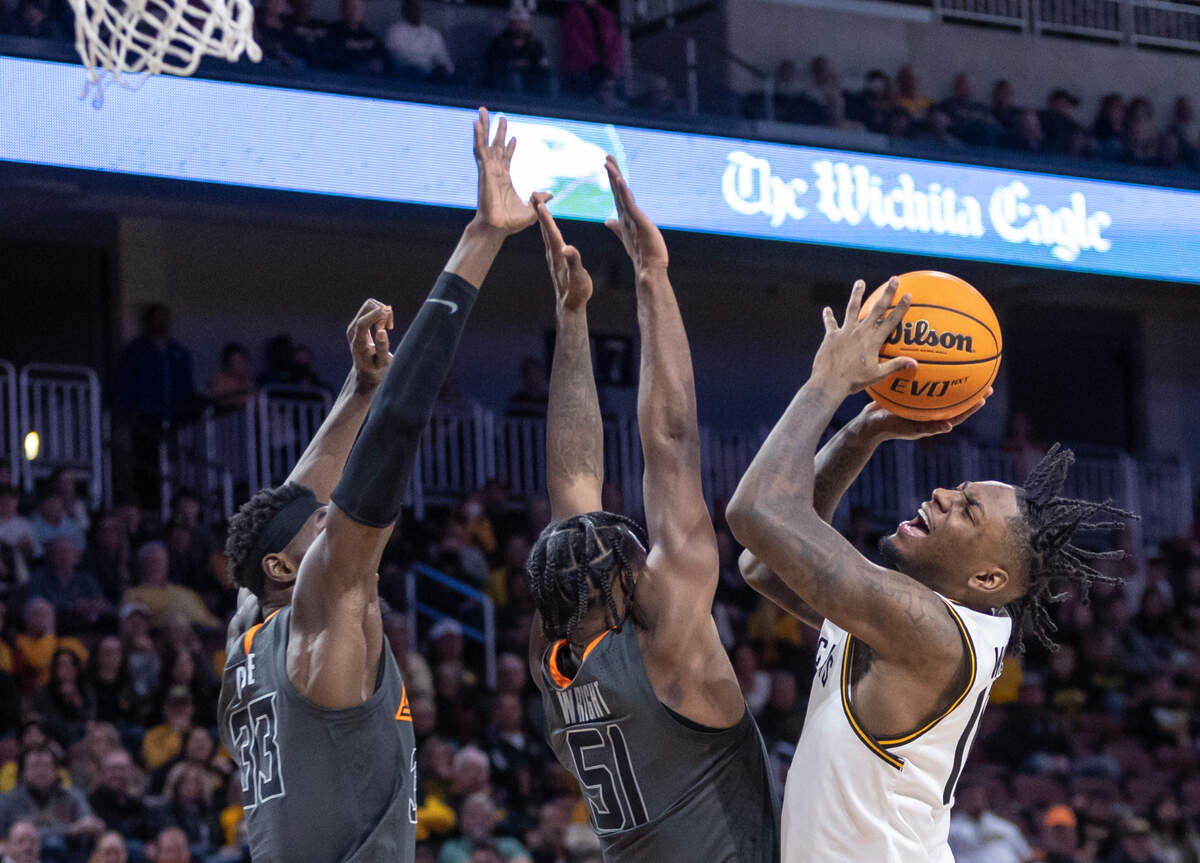 Wichita State’s Jaykwon Walton fights for a shot against Oklahoma State’s Moussa Cisse, left, and John-Michael Wright during the second half of their game at Intrust Bank Arena on Saturday night.