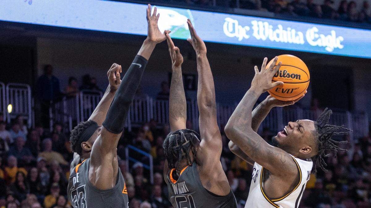 Wichita State’s Jaykwon Walton fights for a shot against Oklahoma State’s Moussa Cisse, left, and John-Michael Wright during the second half of their game at Intrust Bank Arena on Saturday night.