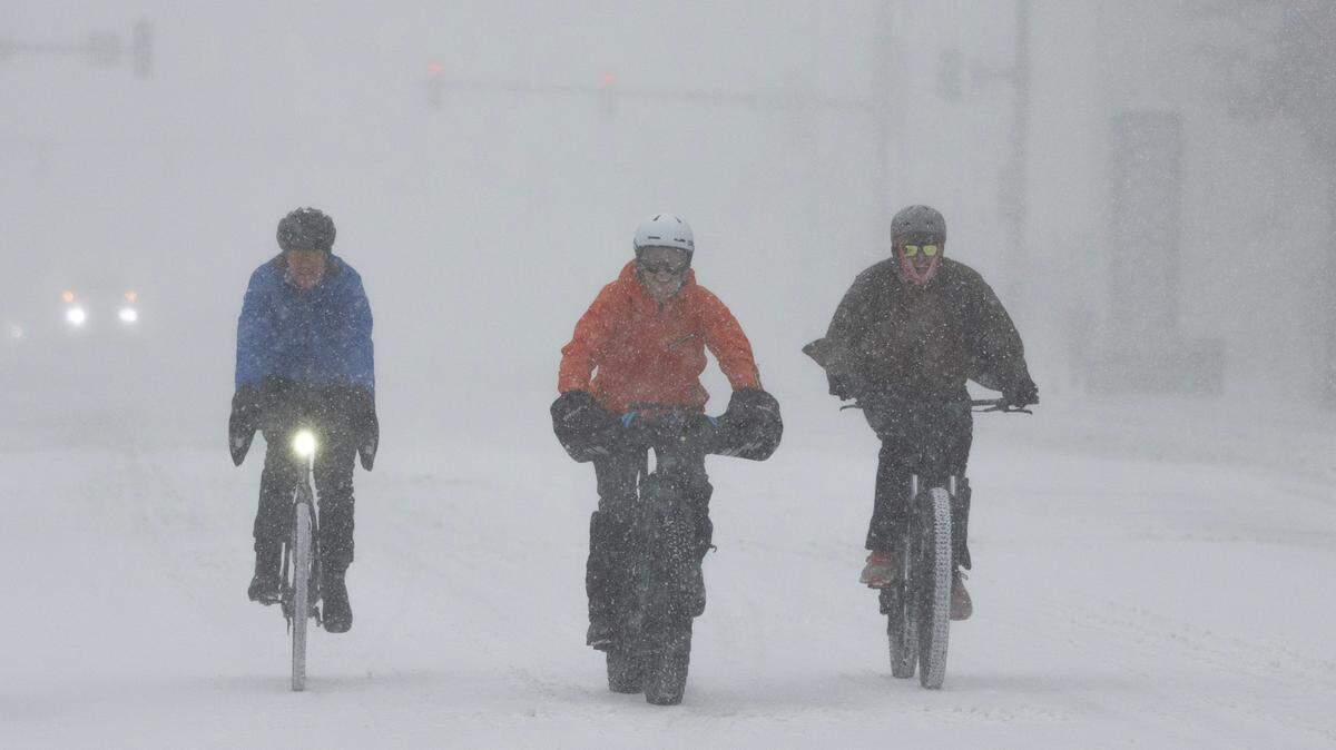 A group of cyclists make way through downtown Wichita during a severe winter storm on Sunday.