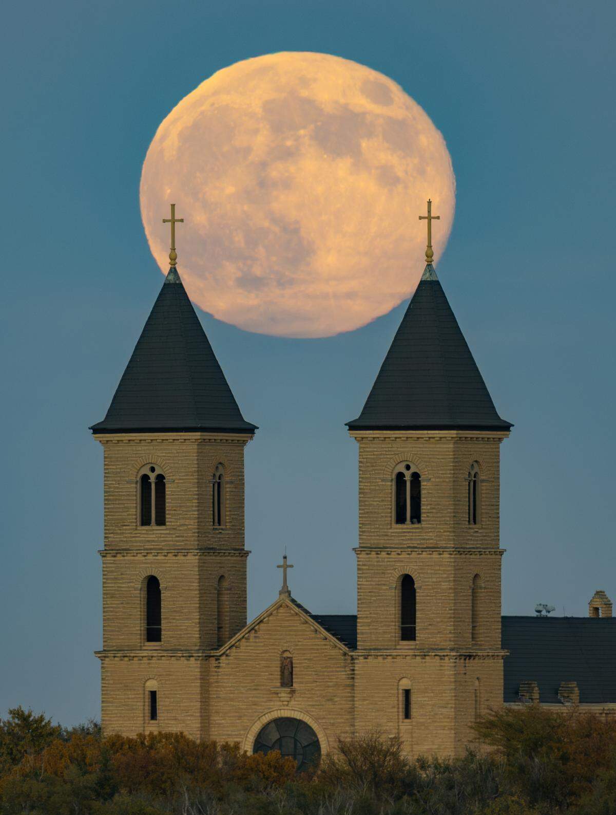 The full moon rises behind the Basilica of St. Fidelis, also known as the Cathedral of the Plains, in Victoria on Nov. 5. The November full moon is known as the Beaver Moon.