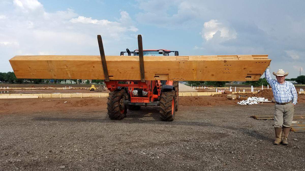 Mike Andra stands with one of the beams he’ll use for the timber-frame event center at his new Wichita Union Stockyards.