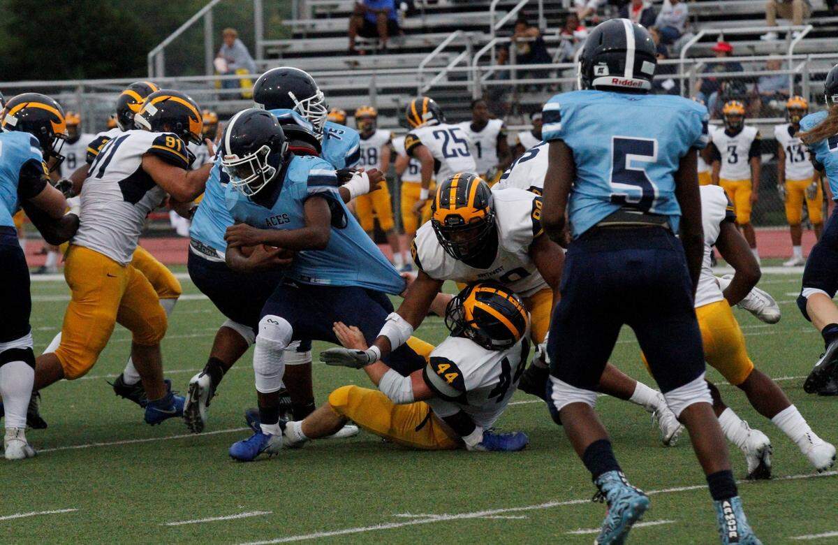 Wichita East junior running back Norman Massey fights through Northwest senior linebacker Josh Carter’s tackle in the Grizzlies’ 56-0 win over the Blue Aces on Thursday night. (Sept. 6, 2018)