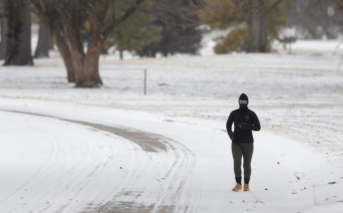 A jogger makes her way through Riverside as temperatures hovered just above zero and wind chills were around -13 degrees. More snow is expected through the day.