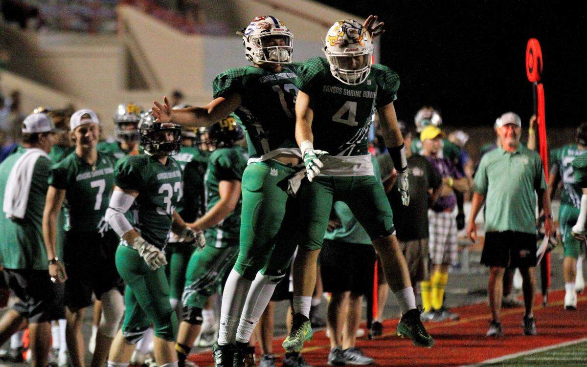 Goddard quarterback Blake Sullivan (left) and Derby running back Brody Kooser (right) celebrate after Kooser’s 8-yard touchdown during the 2018 Kansas Shrine Bowl at Carnie Smith Stadium in Pittsburg, Kansas. The East beat the West 21-14. (July 28, 2018)