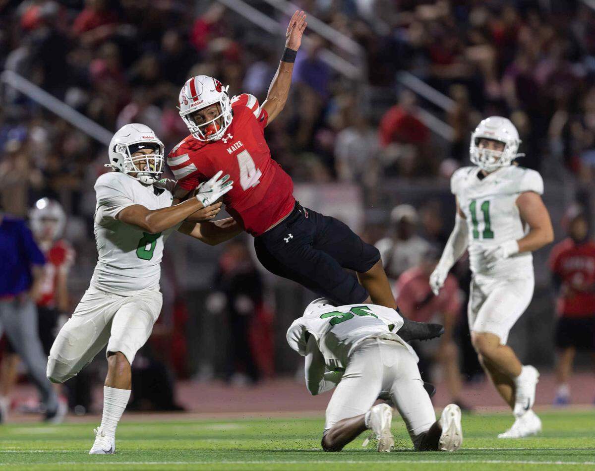 Maize senior quarterback Brayden Myovela flies through the air in a 42-21 win over Derby.