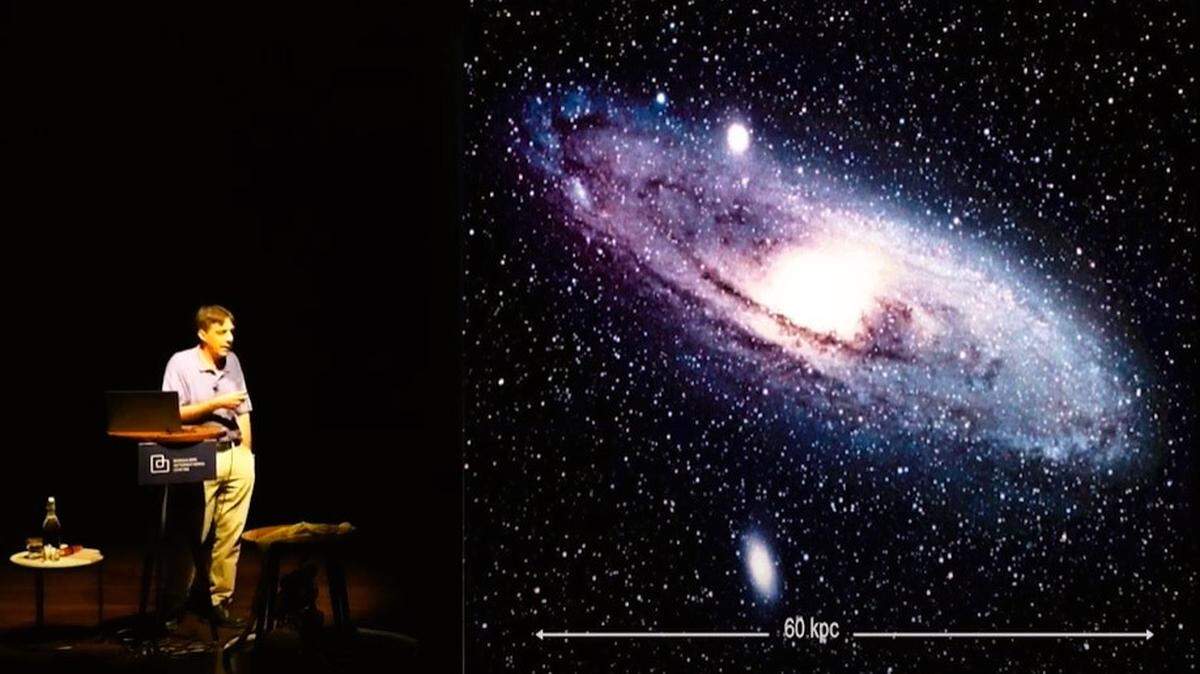 Bharat Ratra, distinguished professor of physics at Kansas State University, stands in front of an image of the Andromeda galaxy as he delivers a lecture on the accelerating expansion of the universe, dark matter and dark energy; at the Bangalore International Institute, in collaboration with the Raman Research Institute, Bangalore, India. Ratra is concerned that cutbacks in U.S. government funding for scientific research will hurt Kansas’ and America’s competitive position in the world.