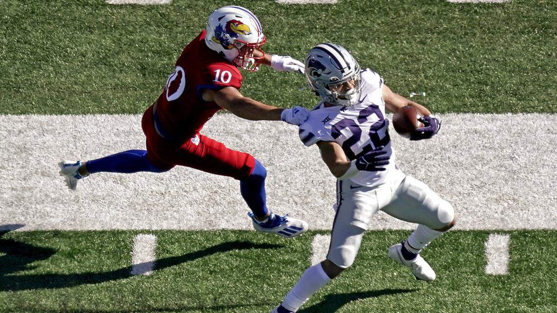 Kansas State running back Deuce Vaughn (22) is tackled by Kansas safety Jayson Gilliom (10) during the first half of an NCAA football basketball game against Kansas Saturday, Nov. 6, 2021, in Lawrence, Kan. (AP Photo/Charlie Riedel)