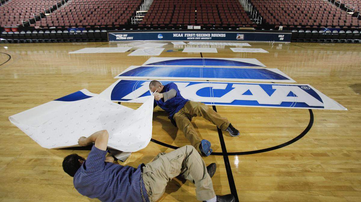 The Operations Crew at Intrust Bank Arena places the NCAA logo onto the basketball court at the arena in preparation of the first and second rounds of the NCAA Wichita Regional. (March 17, 2011)