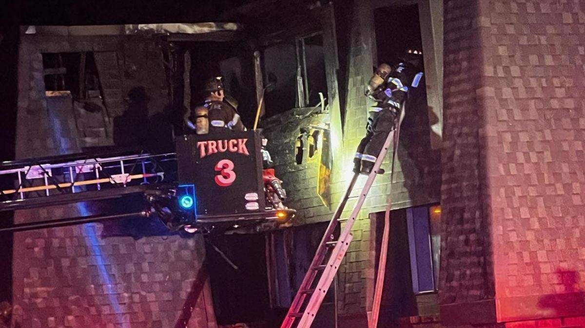 A Wichita firefighter searches through the window of an apartment where a fire injured four people early Friday morning. All six of the units in the apartment are uninhabitable.