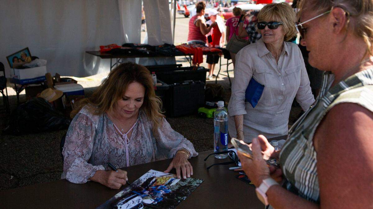 Catherine Bach, the original actress who played Daisy Duke in the TV show “Dukes of Hazzard,” signs autographs during the Mopar Nationals at National Trail Raceway.