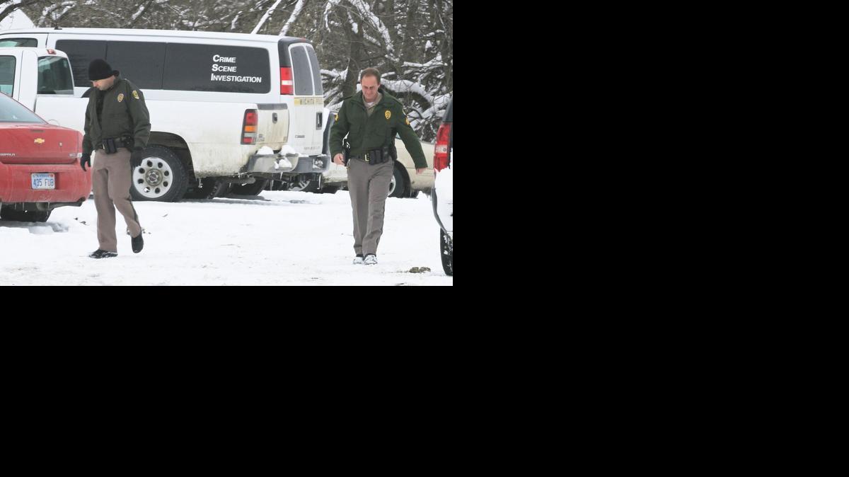 Wichita police officers walk through the parking lot of Steckline Communications as police investigated the death of Daniel Flores, an employee at the business near Maize and Kellogg. (Feb. 10, 2014) 

