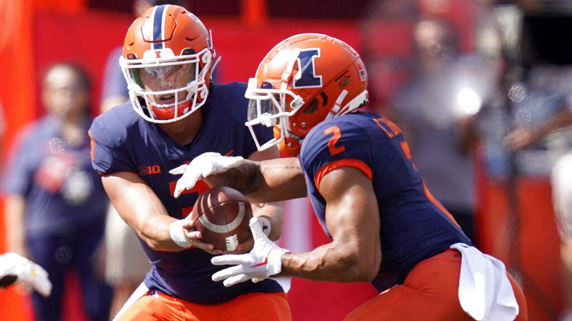 Illinois quarterback Tommy DeVito hands off to running back Chase Brown during the first half of last weekend’s game against Wyoming in Champaign, Ill.