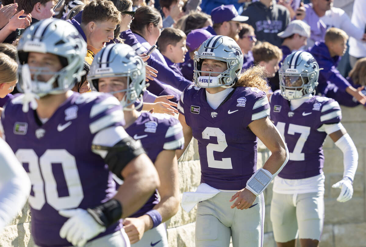 Kansas State quarterback Avery Johnson celebrates with fans after the Wildcats defeated Kansas for the 18th straight time in Manhattan on Saturday.