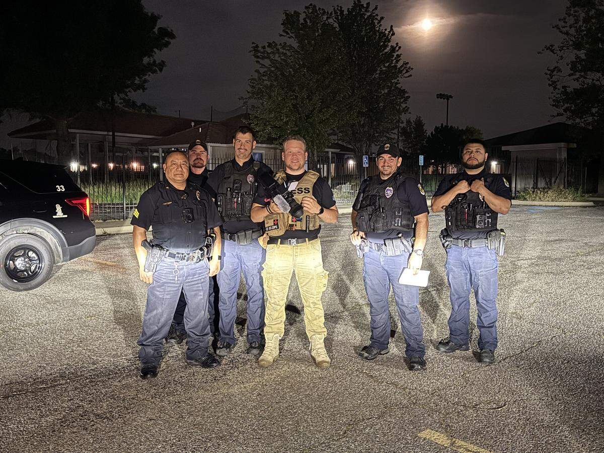 Benjamin Rambaum, fourth from left, smiles for a photo with Wichita Police Department officers while filming US COPS.