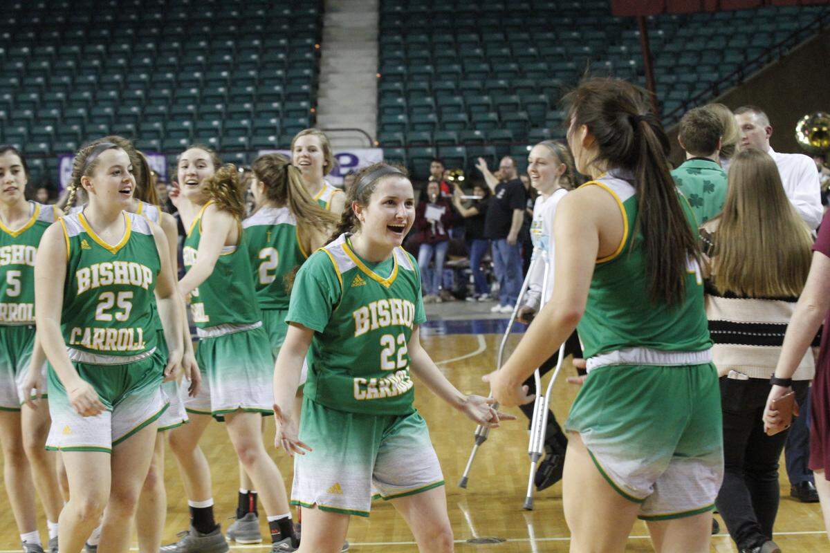 Carroll's Allison McFarren (center) celebrates with Britney Ho (right) after the Eagles' 52-38 victory against No. 1 Liberal on Friday to clinch their spot in the Class 5A girls basketball championship game at the Kansas Expocentre in Topeka.