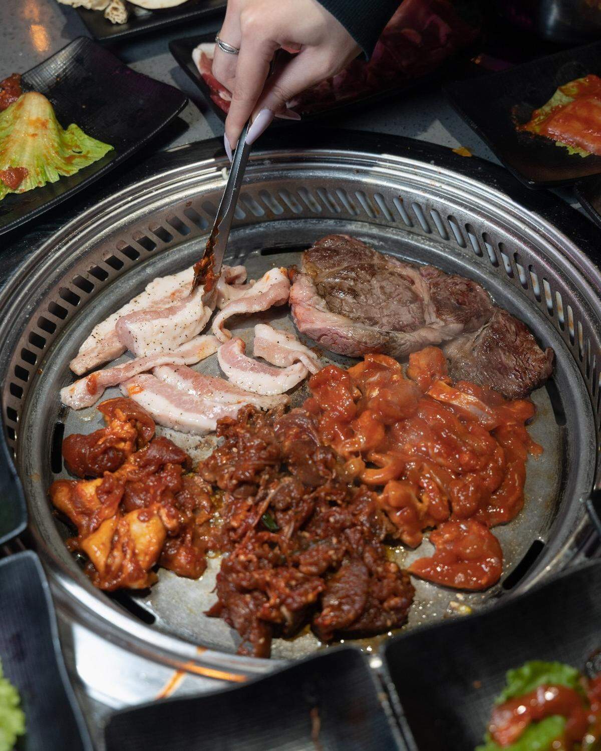 KPOT diners choose various meats and veggies then cook them at grills built-in to their tables.