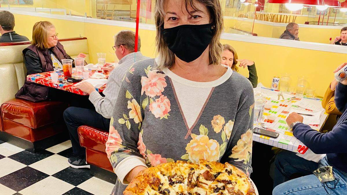 Timirie Shibley shows off Doo-Dah Diner’s new meatloaf pizza, available to go in the evening hours.